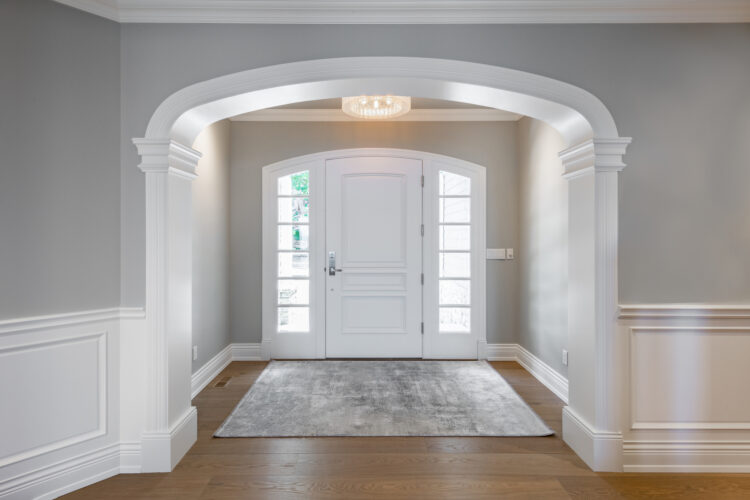 Elegant entryway with decorative door trim and archway