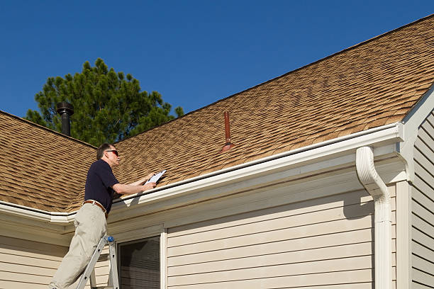 Roof inspector assessing shingles for damage reports